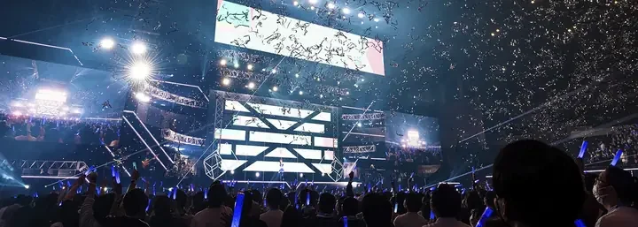 紙吹雪が舞うステージと青いペンライトが光る客席