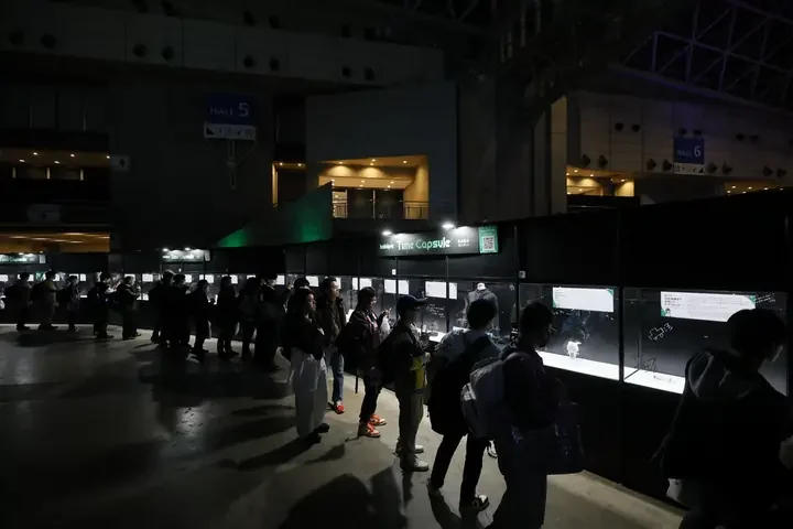 「hololive Time Capsule」の展示ケースをのぞく来場者