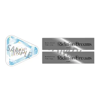 「hololive 7th fes. Ridin'on Dreams」のロゴ入りの銀テープ2本と、三角形の紙吹雪風ステッカー
